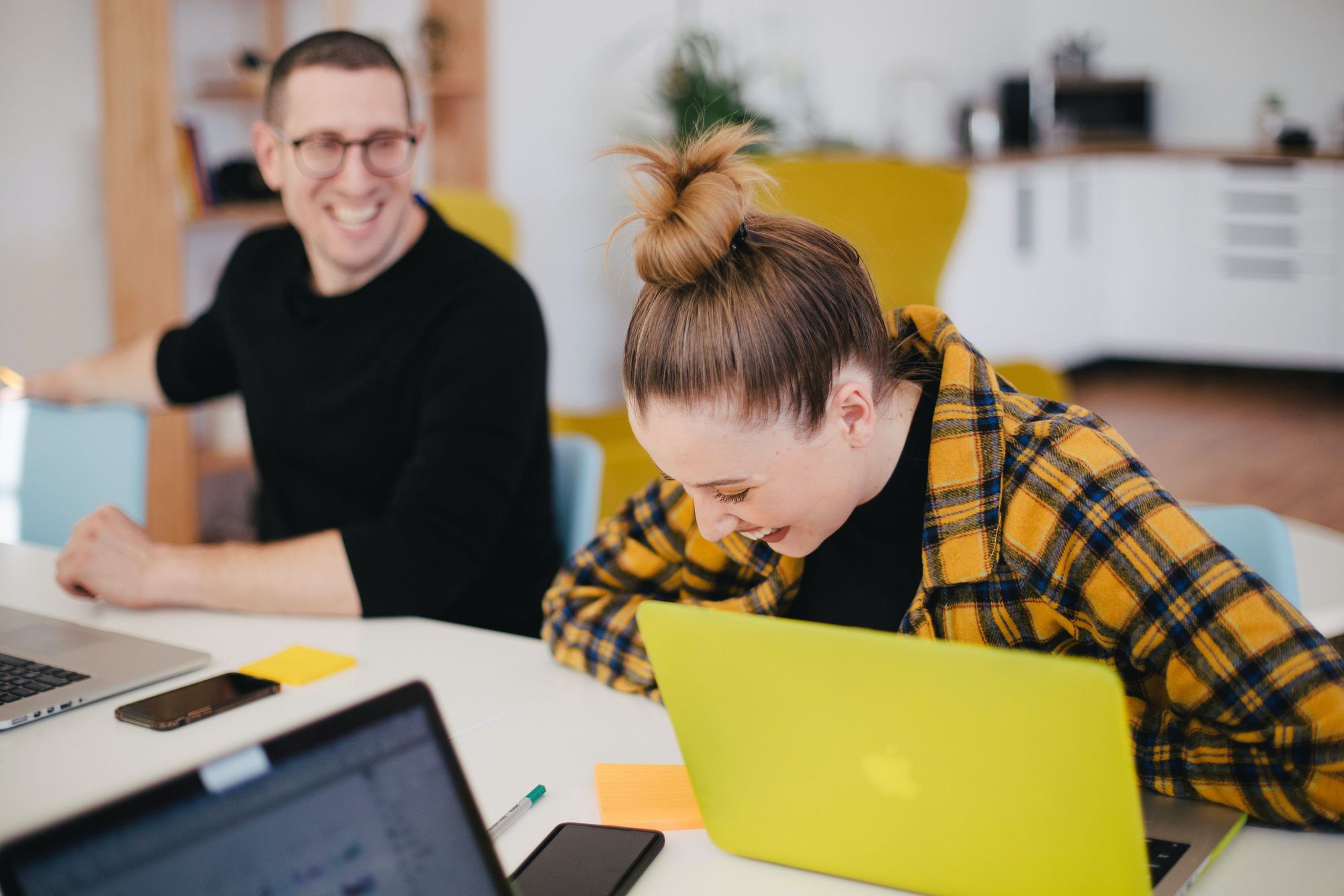 A man and a woman laughing at work